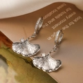 Macro shot of silver ginkgo leaf earrings with shimmering zircons and silk backdrop - Ginkgo Leaf Zirconia Dangle(45181)