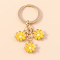 Lindo llavero dorado con tres dijes de margaritas amarillas para bolsos y móviles - Amarillo
