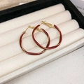 Detailopname van golvende gouden oorringen met een dieprode emaille afwerking - Rood Goud Gedraaid Ontwerp (25# Zilveren Pin)