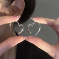 Minimalist Y2K heart hoop earrings in polished silver finish held by hand - Hollow Heart (17#)
