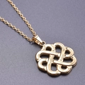 Macro shot of gold-plated stainless steel Celtic knot pendant on a thin cross chain - Gold Necklace