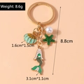 Detail of mermaid and starfish shell keychain with pearl pendants and size measurements - Green