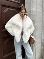 Close-up of white faux fur coat featuring fluffy texture and luxury oversized lapels - XS / White