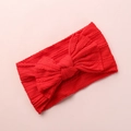 Close-up of a red baby headband with a large jacquard knit bow on a pink background - Red