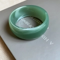 Detailed view of wide bean green acrylic bangle with natural marbled texture - Green