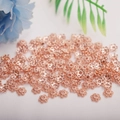 Macro shot of rose gold flower bead caps for DIY jewelry making with petals - 6mm Hollow Bead Cap / Rose Gold