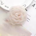 Close-up of elegant cream white lace rose fabric flower DIY accessory on a plate - White
