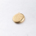 Makroaufnahme eines Medaillons aus 316L Edelstahl mit antiker Blumengravur in Gold - Gold