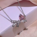 Pink heart and bow zircon necklace set in silver finish on soft silk background - Necklace