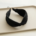 Close-up of black knotted headband with premium matte texture in a minimalist tray - Black