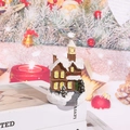 Detailed view of a miniature resin Christmas snow house with festive glowing LED windows - 22 Style C