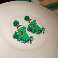 Christmas green dinosaur earrings with red scarf and Santa hat on white ceramic plate - 86# Christmas Dinosaur Drop Earrings