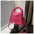 Detalle del bolso trapezoidal rosa con asa redonda única y acabado en cuero mate - rosa intenso