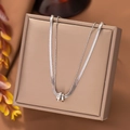 Detailed view of silver double-layered titanium steel necklace with zircon interlocked rings - Transfer Ring / Steel