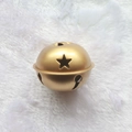 Golden 5cm metal Christmas bell with star cutouts on a white plush background - Star Painted Gold