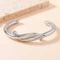 Polished silver stainless steel open bangle featuring a unique twisted knot design - Silver Twisted Style