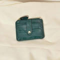 Dark green leather card holder with snap closure and zipper pocket on satin background - Dark Green