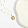 Golden oval cross necklace with heart and colored zircon on a minimalist white backdrop - Colorful Zirconia Heart