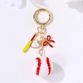Baseball keychain with red bow, mini bat, and love heart charm on golden ring - Gold Baseball Bat Heart Bow Set