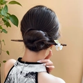 Detailed view of wood hair pin featuring white flowers and green leaves on a model - White Flower Green Leaf Style (130#)