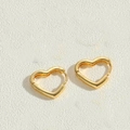 Macro view of polished gold heart-shaped hoop earrings with a minimalist sleek design - Heart Earrings / 14K Gold