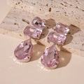 Vista macro de los pendientes largos de cristal rosa sobre piedra beige - Rosa (Poste de pendiente de plata)