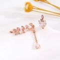Dettaglio macro di orecchini a foglia asimmetrici in oro rosa con zirconi brillanti - Gioielli asimmetrici a foglia (F08) / Oro rosa