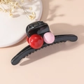 Dettaglio di un mollettone nero con sfere decorative lucide rosse e rosa - Rosa Rosso