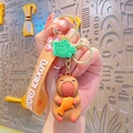 Cute capybara plush keychain holding a fish with Lucky Day wrist strap and green turtle charm - Resin Capybara - Goldfish