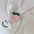 Detailed view of a cute pink peach hair claw clip made of glossy acrylic on a white surface - Peach Pattern