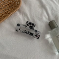 Detail of a black and white marble pattern rectangular hair claw on a white fabric background - Black and White Leopard Print