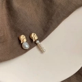 Macro detail of asymmetric baroque pearl earrings with matte gold metal finish - Style 10