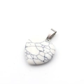 White turquoise stone heart pendant with black veins and silver bail on white background - Howlite