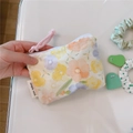 Close-up of mini floral cotton pouch with zipper and simple wish label - Yellow-Orange Floral