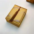 Macro view of golden woven fabric jewelry gift box with silk tassel decoration - Necklace Pendant Box (Medium Square)