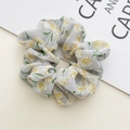 Close-up of floral chiffon scrunchie with blue background and yellow flower pattern - Blue Floral