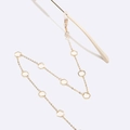 Detail der goldenen Brillenkette mit weißen sechseckigen Harzakzenten und Gummischlaufen - Sechseck