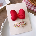 Détail d'un ensemble barrette nœud rouge et pince à fleurs sur carte de support - Groupe Nœud Rembourré