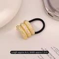 Elastic hair tie featuring a curved golden textured metal plate with pleated finish - Lava Rock Triple Row Gold