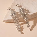 Detail of elegant silver tassel earrings with flower crystal clusters on marble surface - Silver Rhinestone Flower Tassel Style