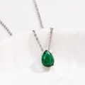 Macro view of teardrop emerald pendant in four-prong silver setting on link chain - Style 1 Silver (Pear Shape)