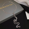 Detail van een zilveren gelaagde ketting met een geknoopt kwastje op zwart fluweel - Zilver