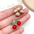 Sweet red cherry pendant with green rhinestones and pearls held on fingertips - KC Gold Red Resin Green Rhinestone Cherry (23426)