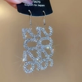 Nahaufnahme glitzernder silberner geometrischer Ohrringe mit Kristallbesatz - Ohrhaken - Silber - Geometrisches Muster