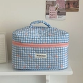 Detail view of the blue checkered quilted fabric and the jolly house woven label - Makeup Bag / Blue