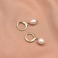 Elegant gold hoop earrings with white baroque pearl pendants on pink silk background - Simple Hoop Earrings
