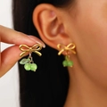 Dettaglio orecchini a fiocco dorato con ciondoli a perline verdi indossati da modella - Orecchini a lobo ciliegia verde placcati oro 18K (11343)
