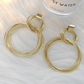 Detailopname van gouden gelaagde metalen oorringen op een witte achtergrond van imitatiebont - Goud