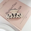 Detalle del clip de pelo beige con patrón de lazo negro y brillantes diamantes de imitación - 7,8 cm / Beige-Negro