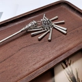 Detail of silver tassel hair stick with retro hollow design on a dark wood tray - F0742 Hair Stick-35# (Silver Hollow Five Column Tassel)